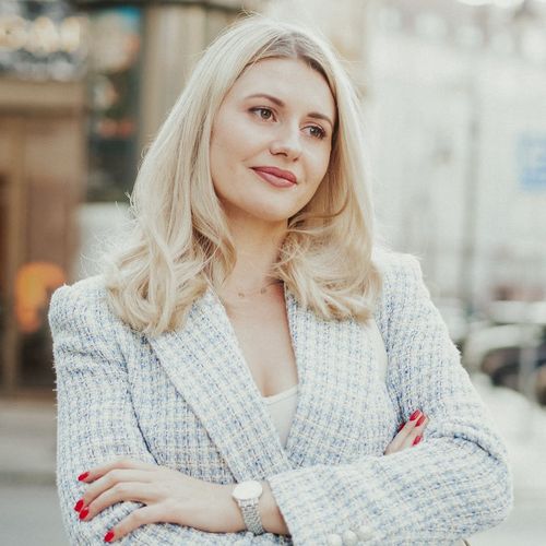 Portrait of a smiling professional woman, Svitlana Shevchenko, in a contemporary setting.